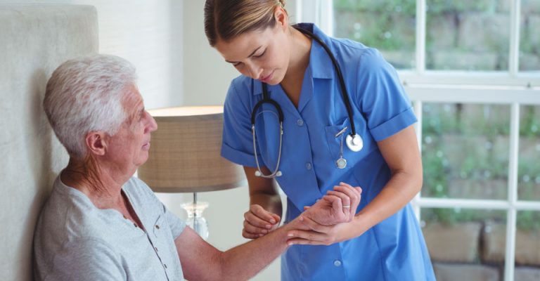 Hazelcare support worker examining senior man while providing emergency care